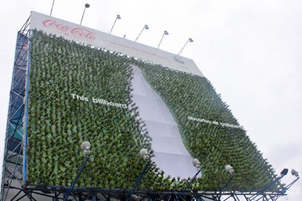コーラとＷＷＦの緑化プロジェクト屋外看板。ボトルの背景に植樹がされていて、環境保護を訴えています。
